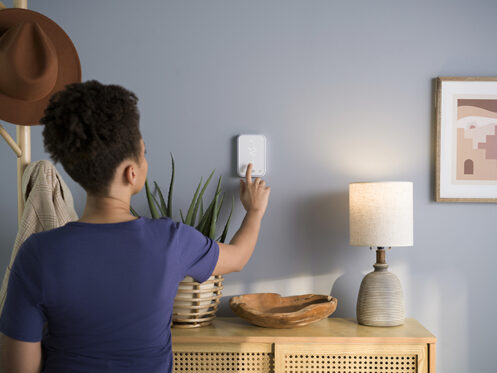 Woman setting a smart thermostat